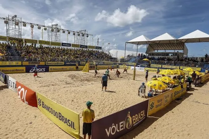 Partida de vôlei de praia sendo disputada na areia